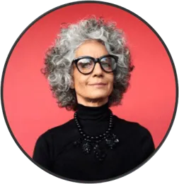 Portrait d'une femme aux cheveux gris bouclés, lunettes noires, sur fond rouge